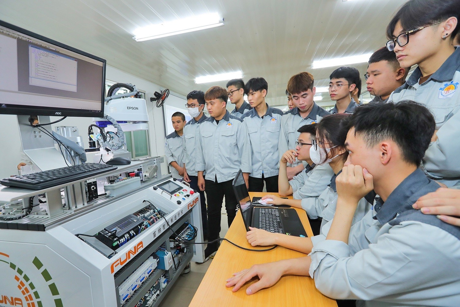 Sinh viên thực hành lập trình điều khiển cánh tay robot tại Trung tâm đào tạo sản xuất thông minh HNIVC-FUNA của Trường Cao đẳng Công nghiệp Hà Nội phối hợp với đối tác quốc tế thành lập _Nguồn: TTXVN Sinh viên thực hành lập trình điều khiển cánh tay robot tại Trung tâm đào tạo sản xuất thông minh HNIVC-FUNA của Trường Cao đẳng Công nghiệp Hà Nội phối hợp với đối tác quốc tế thành lập _Nguồn: TTXVN