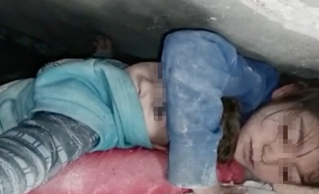 Động đất ở Thổ Nhĩ Kỳ - Syria: Những câu chuyện đau thương và cảm động Bé gái Syria 7 tuổi đang ôm em trai của mình khi bị chôn vùi dưới đống đổ nát của động đất. Ảnh: Twitter Mohamad Safa