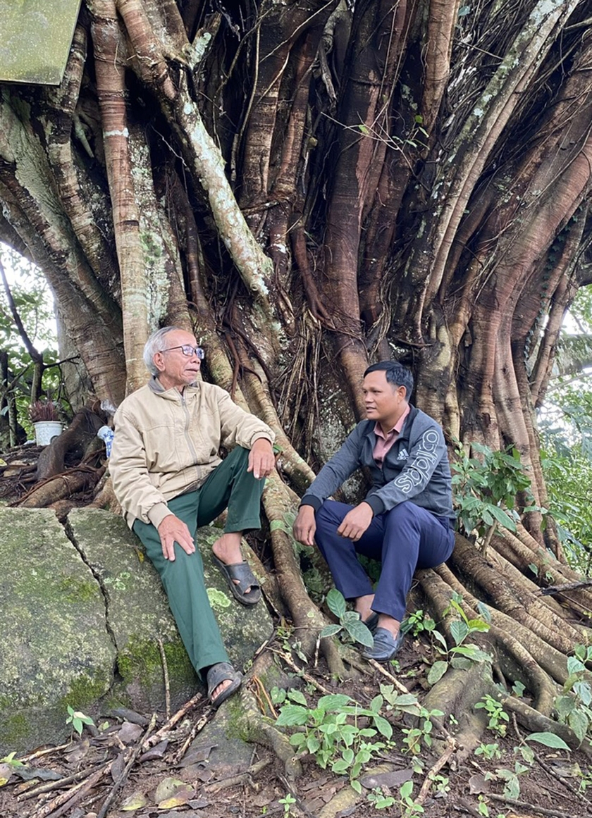 Dưới gốc đa cổ thụ, ông Rơmah Thanh (bìa trái) kể chuyện tham gia kháng chiến cho thế hệ trẻ xã Gào. Ảnh: S.C ảnh 2