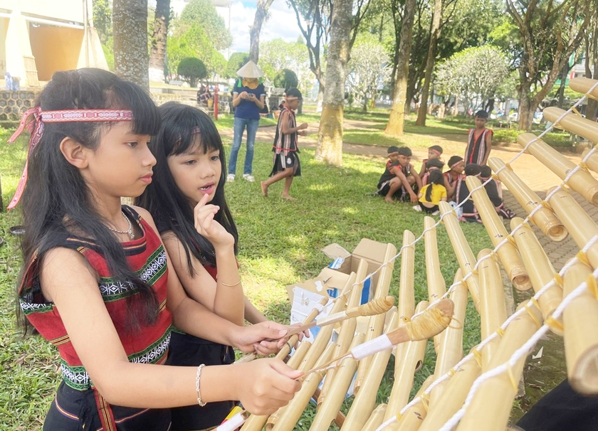H&amp;apos;Srian đứng bên cạnh nhìn cháu gái HSrina chơi đàn T&amp;apos;rưng. Ảnh: Phương Dung
