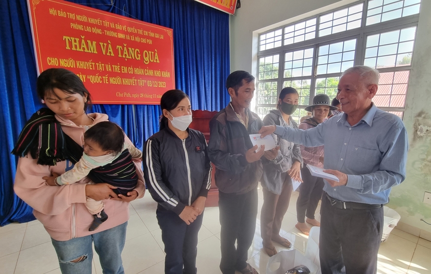 Ông Trương Đình Ba-Chủ tịch Hội Bảo trợ NKT và bảo vệ quyền trẻ em tỉnh tặng quà các gia đình NKT tại huyện Chư Pưh. Ảnh: H.P